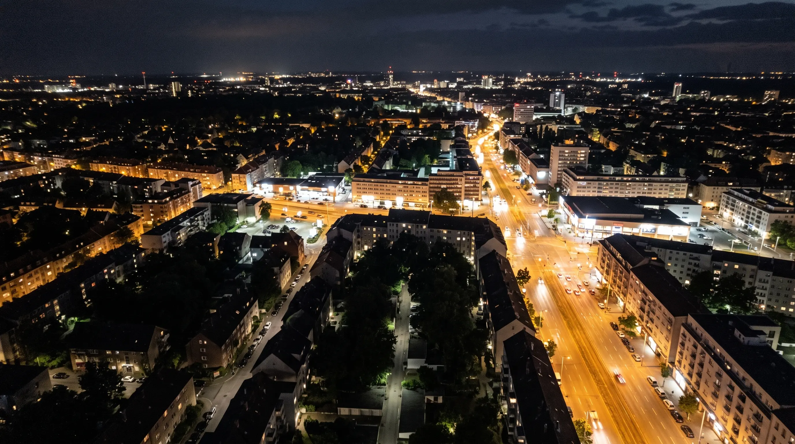Aerial night view of illuminated streets contrasting with darker alleys